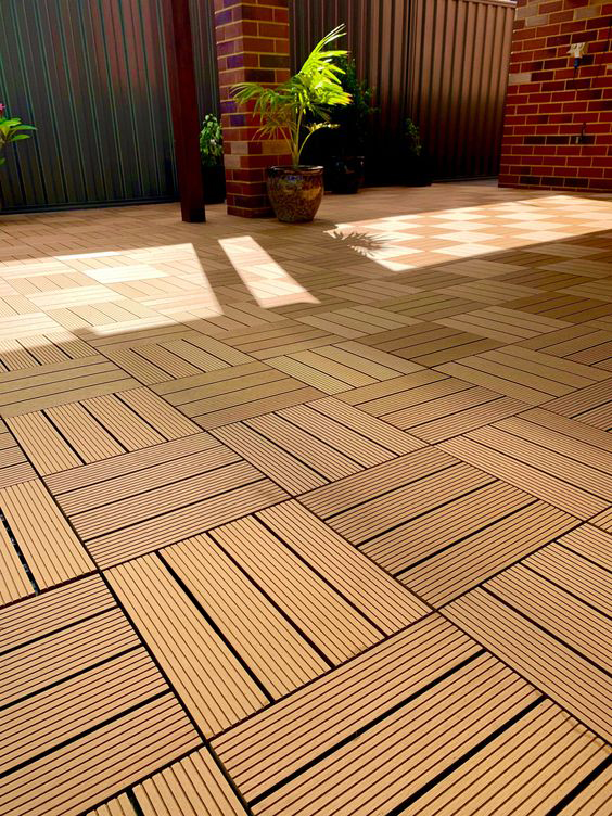 Close-up of WPC deck tiles on an outdoor terrace, showcasing their textured, wood-like surface