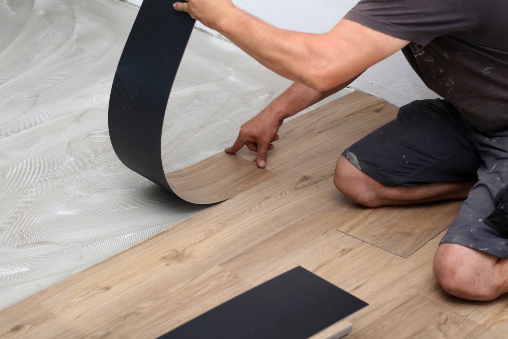 Installer laying down vinyl flooring planks, showcasing the step-by-step process